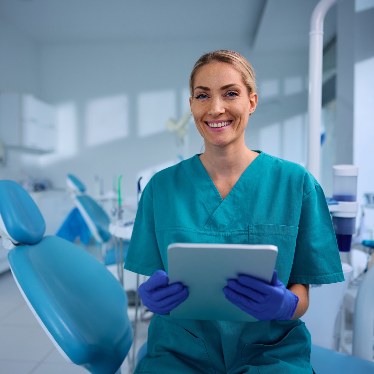 A happy dentist holding the OrthoPhoto dental recordkeeping app